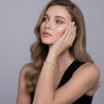 Сребърна тенис гривна с мойсанит Anastasia, носена от жена с дълга, вълниста коса.