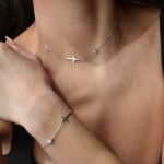 Сребърна гривна с мойсанит Holy, носена на ръка, с елегантен дизайн и кръстче.