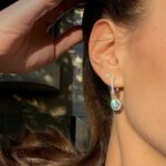 Сребърни обеци с мойсанит Melissa, носени на ухото, с блестящи детайли и цветен камък.