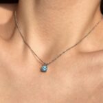 Сребърно колие със син мойсанит Ocean, носено на врата, с видим син камък.